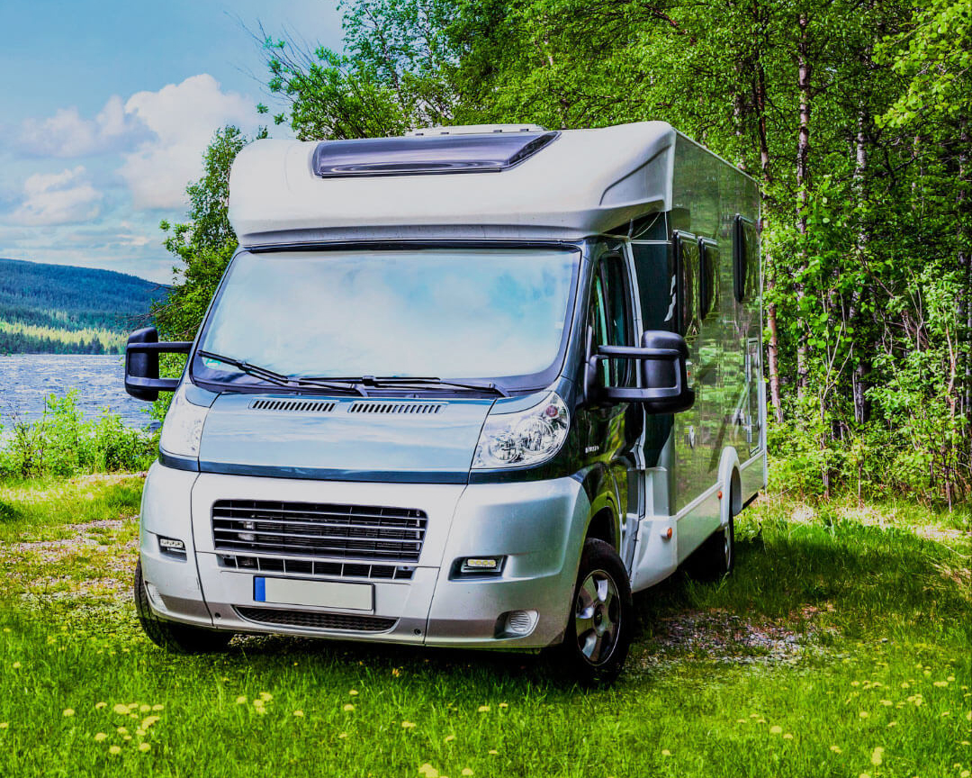 motor home situated by a river in a green landscape, during henley royal regatta