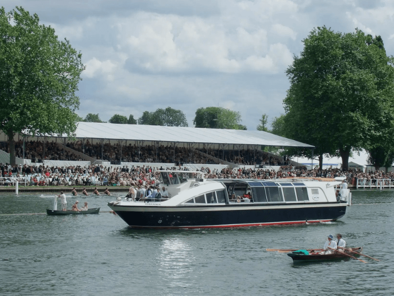 Hobbs of Henley River Taxi sailing along the river while spectators watch from the grand stands